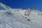 La montée se fait dans le couloir à gauche du massif rocheux du centre de la photo