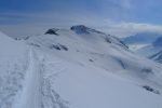Une trace de ski file vers le barrage d'Emosson. Le Mont-Blanc dans les nuages