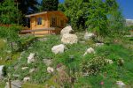 Le cabanon de l'exposition temporaire et un des serres au fond