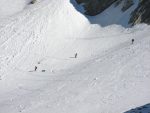 un groupe de skieurs dont le maitre descend avec son chien