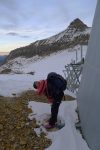 On s'abrite du vent à côté de la piste de luge pour remettre les crampons