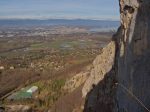 Vue surplombante sur la face des Varappes, avec trois grimpeurs et au loin le jet d'eau de Genève