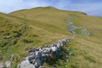 Vieux mur de pierres sèches. La croix à droite