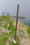 La croix rouillée et branlante et les installations des Secours en Montagne