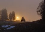 Le soleil se couche derrière la brume.